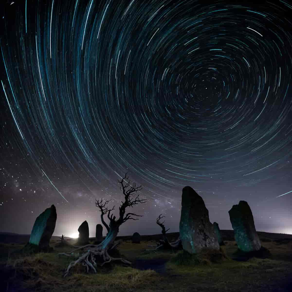 Long-exposure night photograph of concentric star trails above an ancient stone circle on a windswep